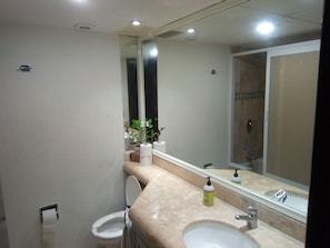 A bathroom with a toilet, sink, and mirror. - Ocean Front Suites by Rodero Condos (Cancun)