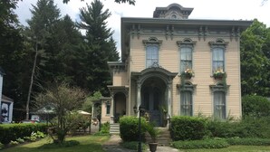 A stately two-story building with a symmetrical facade, large windows, and a prominent entrance.