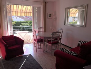 A room with a dining table and chairs, a sofa, and a large mirror. - Close to beaches, nice apartment 65 m2, with view, in very quiet residence (La Seyne-Sur-Mer)