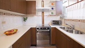 A compact kitchen with wooden cabinets, a built-in oven, a microwave, and a sink. - UNIQUE & STYLISH Boutique-Colonial Loft @ Quito Centro Historic (Quito)