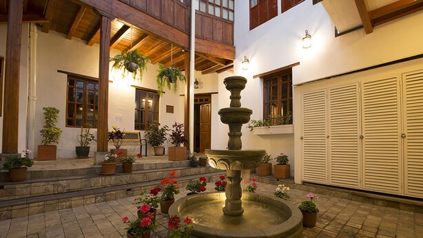 A courtyard with a stone fountain, potted plants, and wooden beams. - UNIQUE & STYLISH Boutique-Colonial Loft @ Quito Centro Historic (Quito)