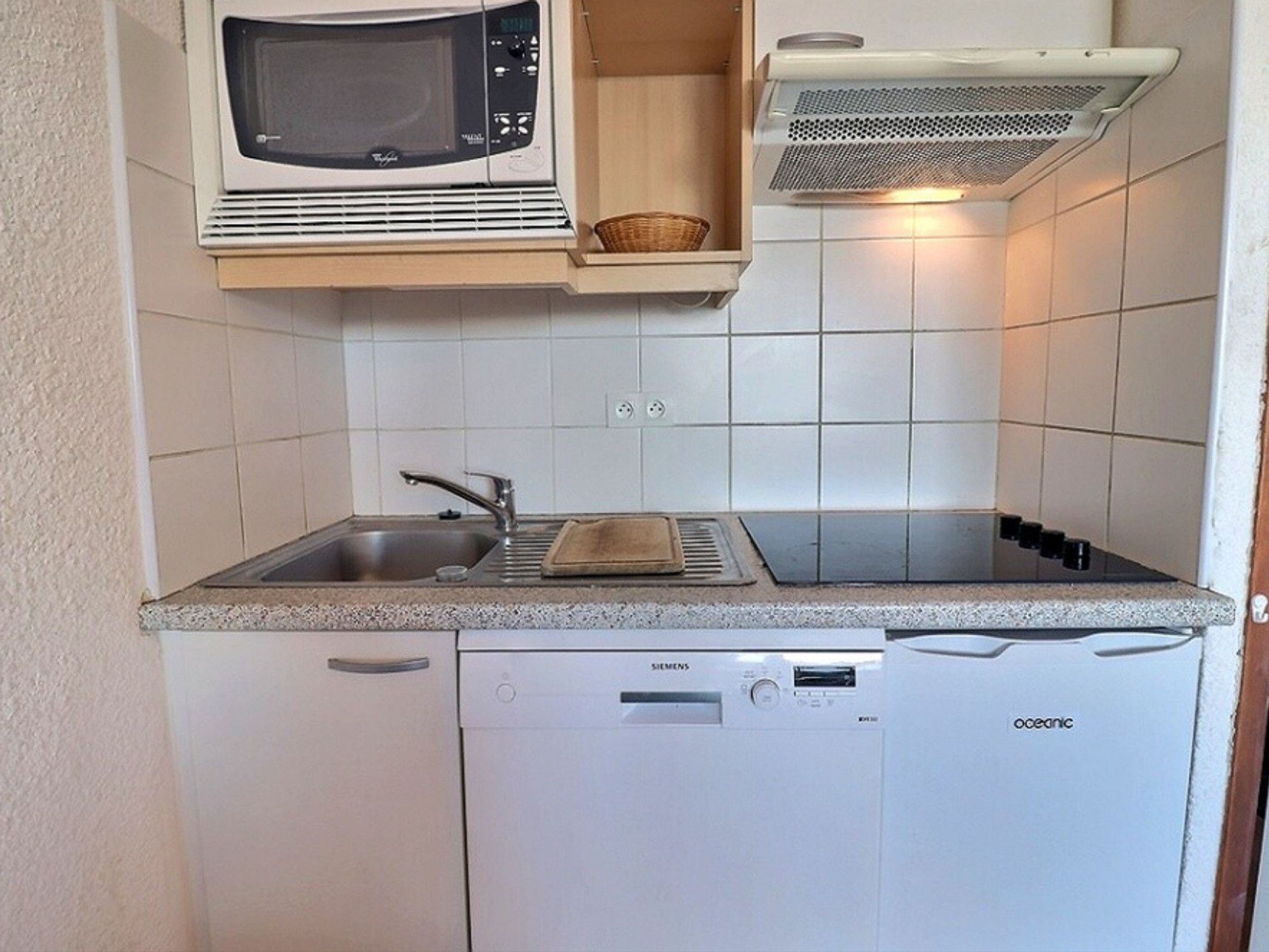 Cuina compacta amb microones, torradora, rentatge i rentavaixelles.