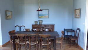 Comedor con mesa y sillas de madera, aparador de madera con tiradores decorativos y lámpara colgante.