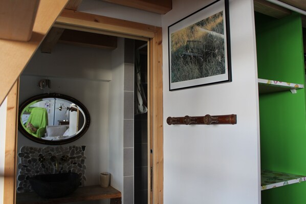 A bathroom with a stone sink, a mirror, and a wooden door. - the cabin appt in house of customs 4 pers. view and direct access sea (carnac)