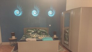 Ein Schlafzimmer mit einem Bett, einem Kleiderschrank und drei Wandleuchten.