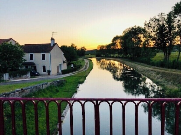 Situated riverside, this property offers a serene view of the calm waterway and surrounding landscape.