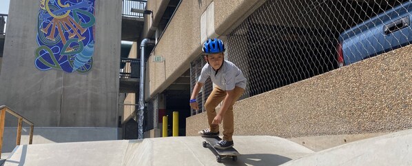 A person skateboarding on a ramp in an urban setting with a concrete wall and a colorful mural. - Contemporary, Updated Vail Condo with Balcony - Walk to Lionshead. (Vail)