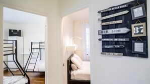 A hotel room with bunk beds, a bedside table, and a wall with directional signs. - ⭐️⭐️⭐️Cathédrale, bright space in the heart of town (Reims)