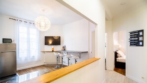 A modern kitchen with a wooden countertop, a built-in microwave, and a bar area with stools. - ⭐️⭐️⭐️Cathédrale, bright space in the heart of town (Reims)