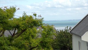 A residential area with a house, trees, and a view of the sea. - Quiet studio near the sea (Binic)