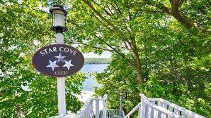 Un panneau indiquant « Star Cove », avec en arrière-plan un lac et un escalier en bois menant à un quai.