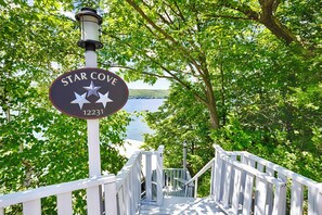 Discover Star Cove, a serene retreat near a tranquil body of water, accessible via a staircase.
