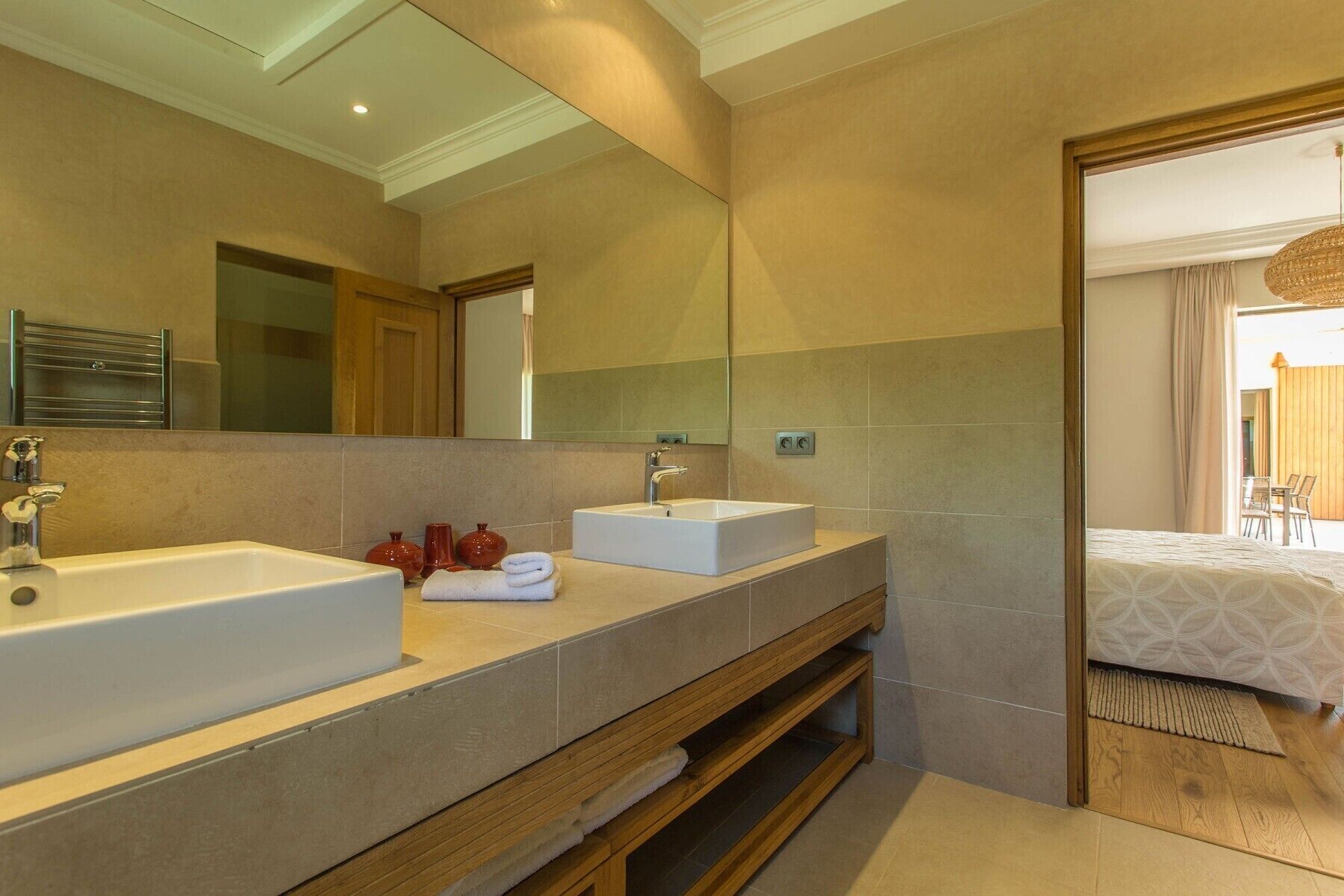 Un baño moderno con dos lavamanos, un espejo grande y un mueble de tocador de madera.