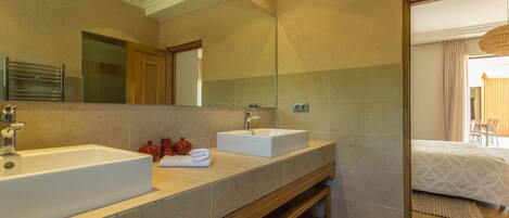 Un baño moderno con dos lavamanos, un espejo grande y un mueble de tocador de madera.
