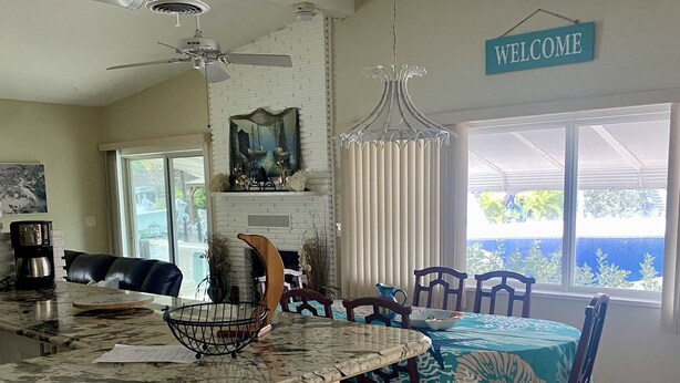 A spacious kitchen with a white brick island, a dining area with a table and chairs, a ceiling fan, and a 'WELCOME' sign. - Ground floor no stairs close to everything Atlantic side  (Marathon)