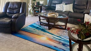 A living room with a leather sofa, a leather armchair, a glass coffee table, and a rug with a sunset design. - Ground floor no stairs close to everything Atlantic side  (Marathon)