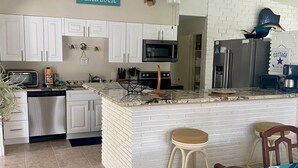 A kitchen with white cabinets, a microwave, a refrigerator, and a sign that reads "BEACH HOUSE". - Ground floor no stairs close to everything Atlantic side  (Marathon)