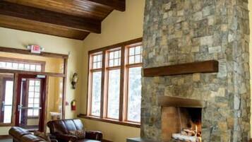 A spacious lobby with a stone fireplace, leather seating, and a chandelier.
