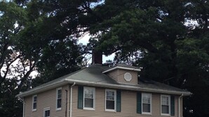 A two-story house with a central entrance, multiple windows, and a chimney. - JACARANDA.  A comfortable, secure two-story colonial.  Whole house.  (Milton)