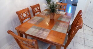 A wooden dining table with a patterned tablecloth, surrounded by wooden chairs. - Ly217376 - Oak Island Cove - 4 Bed 3 Baths Villa (Kissimmee)