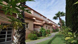 A multi-story building with balconies, a well-maintained lawn, and various plants. - New 2010 - 1 bdrm penthouse, ocean front, south and north facing terrace, luxury (Garachico)
