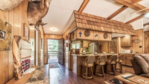 Ein rustikales Blockhaus-Interieur mit Holzwänden, einer Küchenzeile und einem Essbereich.