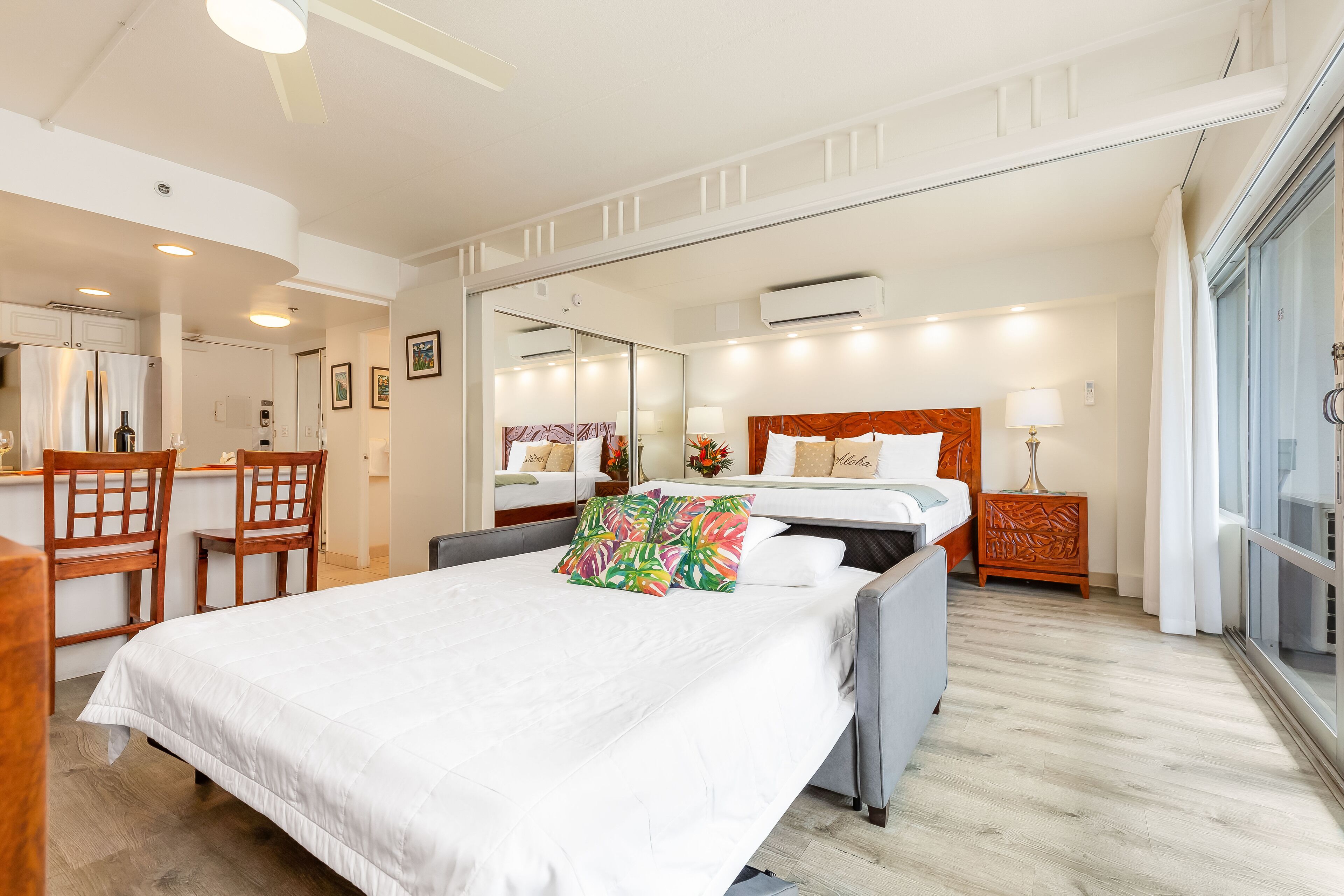 Een hotelkamer met een bed, een bureau, een stoel, een spiegel en een raam.