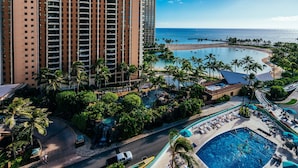 A resort with a large pool, palm trees, and a view of the ocean. - Ocean & Fireworks Views Condo at the Ilikai Hotel w/Full Kitchen & Free WiFi (Honolulu)