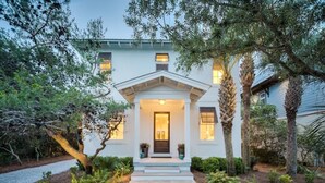 A house with a front porch, a pathway leading to the entrance, and a well-maintained garden with various plants and trees. - Gulf Views-Private Heated Pool-5 bikes included! (Santa Rosa Beach)