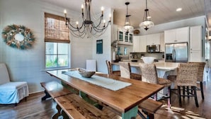 A kitchen with wooden countertops, a central island, and a dining area with a long table and benches. - Gulf Views-Private Heated Pool-5 bikes included! (Santa Rosa Beach)