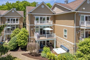 A multi-story residential building with balconies, outdoor seating, and a hot tub.