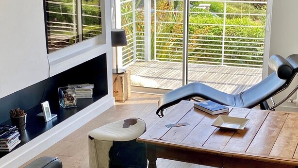 A modern living room with a wooden coffee table, leather sofas, and a TV mounted on the wall. - VERY NICE HOUSE with SEA VIEW and garden overlooking coastal path (Concarneau)