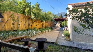 A wooden fence, a birdhouse, a small garden with flowers, and a building with a tiled roof. - Wunderful and cosy house in the heart of the canyon Verdon (Castellane)