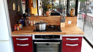 A kitchen with a wooden countertop, a stove, an oven, and various kitchen utensils. - Wunderful and cosy house in the heart of the canyon Verdon (Castellane)