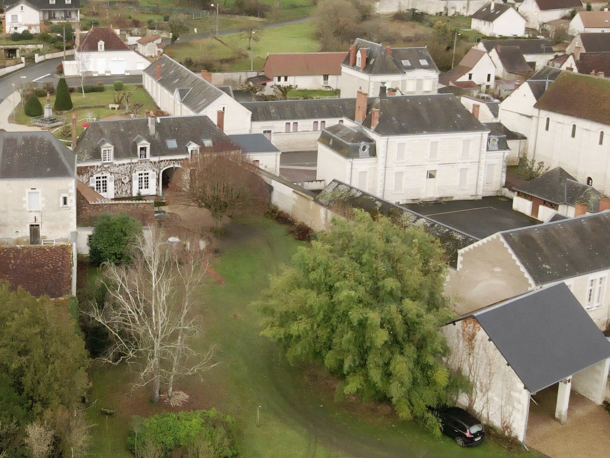 A residential area with houses, a small bridge, and a grassy path.