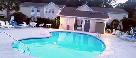 Relax by the pool surrounded by a deck and lounge chairs.