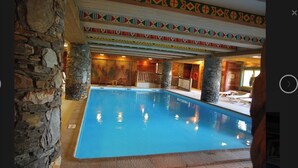 Una piscina amb parets de pedra i un disseny de sostre colorit.