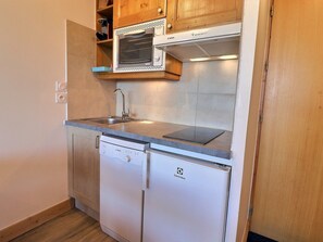 Una cocina compacta con un microondas Bosch, un lavamanos y un lavavajillas Bosch.
