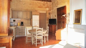 Una cocina compacta con comedor, televisión y chimenea.