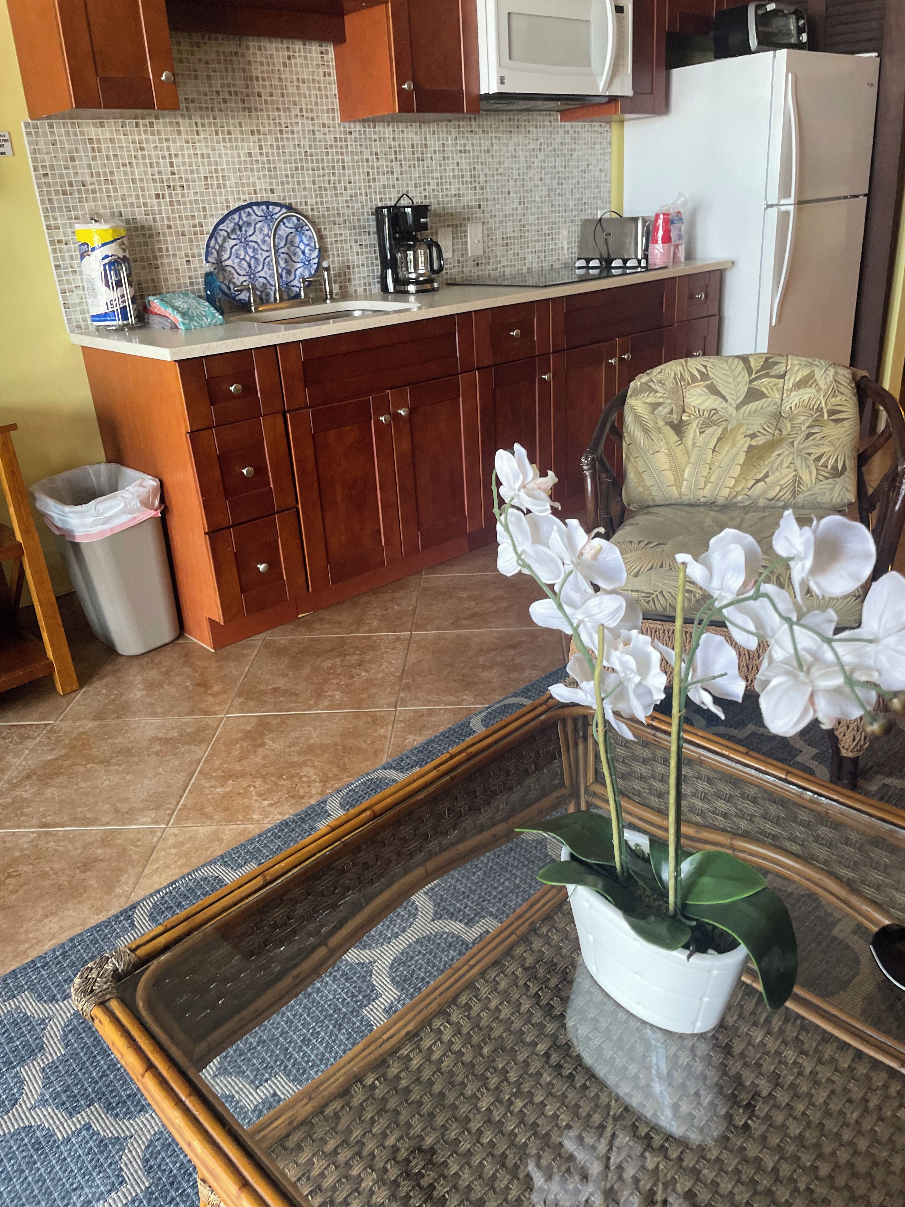 Una cocina con gabinetes de madera, microondas y cafetera sobre la encimera.