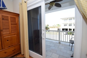 Enjoy the view from your balcony with a single chair, sliding glass door, and a ceiling fan.