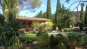 A garden with a stone building, outdoor furniture, and a pool. - SHEEP IN THE REGIONAL PARK LUBERON (Lauris)