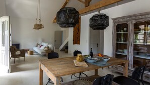 A dining area with a wooden table, black chairs, and hanging black wicker lamps. - Charming villa with swimming pool close to the center of St Rémy de Provence 4-6 (Saint-Rémy-de-Provence)
