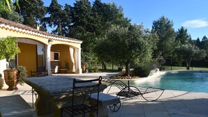 A poolside area with a covered seating area, a pergola, and a view of the pool. - Gîte de provence jacuzzi (Velleron)