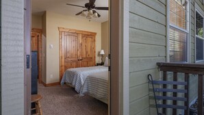 Quarto com duas camas, um ventilador de teto e um guarda-roupa de madeira.