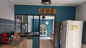 Eine moderne Küche mit Holzausziehtüren, einer Kaffeemaschine und einem Kühlschrank.