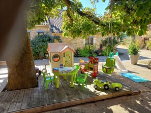 A children's play area with a playhouse, green chairs, a slide, and a toy tractor. - Quercynoise farm w/ pool, peaceful setting, in the vineyards of wine from Cahors (Duravel)
