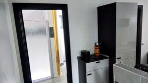 A modern kitchen with a black and white cabinet, a toaster, and a coffee maker on the counter. - Comfortable cottage 3 *** in the Vaunage (Boissières)