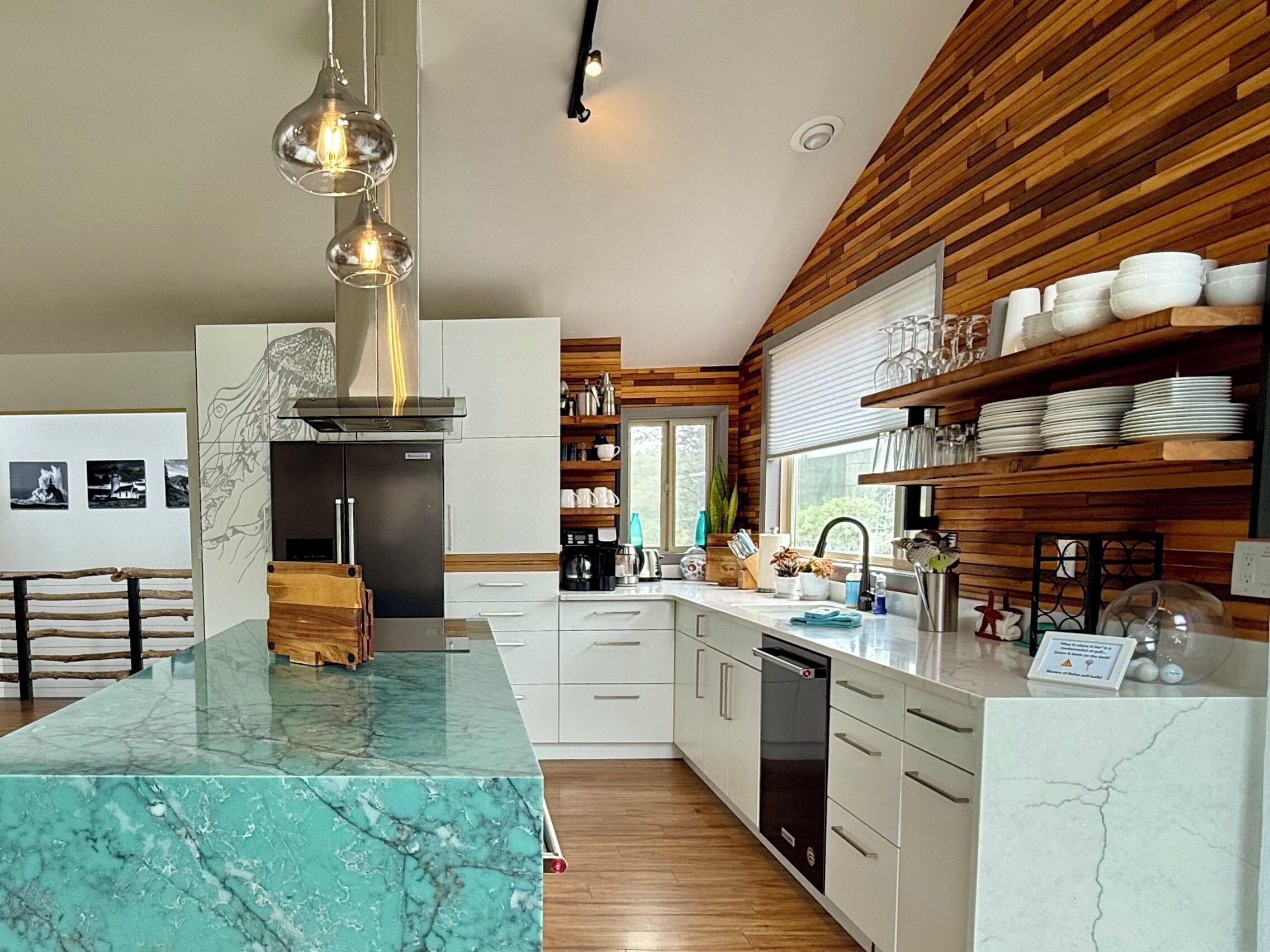 A modern kitchen with a marble island, wooden paneling, and a built-in oven.