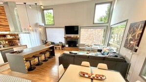 A modern living space with a kitchen, dining area, and seating area.